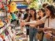 Friends exploring vibrant market with colourful custom keychains for a fun outing.
